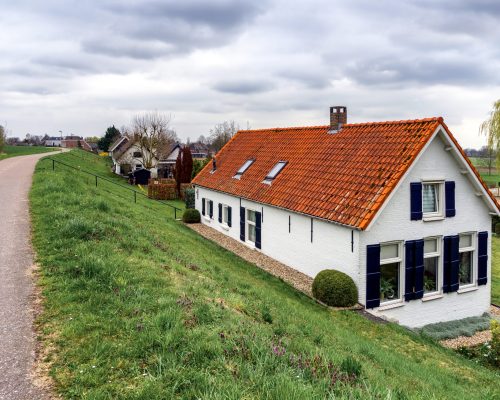 Houses behind the river dikes near Sleeuwijk (NL) on a day with overcast
